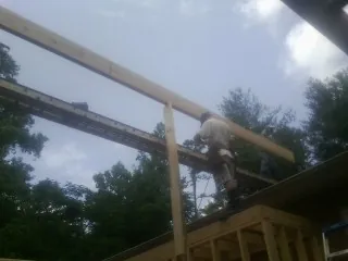 Carpenter setting a ridge beam over a new addition frame — Ice Dam Removal by Roofing Brothers in Silver Star