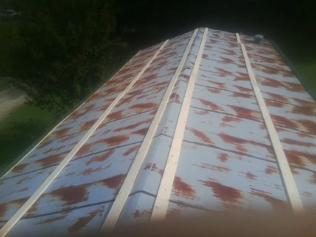 Rusted metal roof panels with new wood purlins before replacement — Storm Damage Roof Repair in Silver Star by Roofing Brothers
