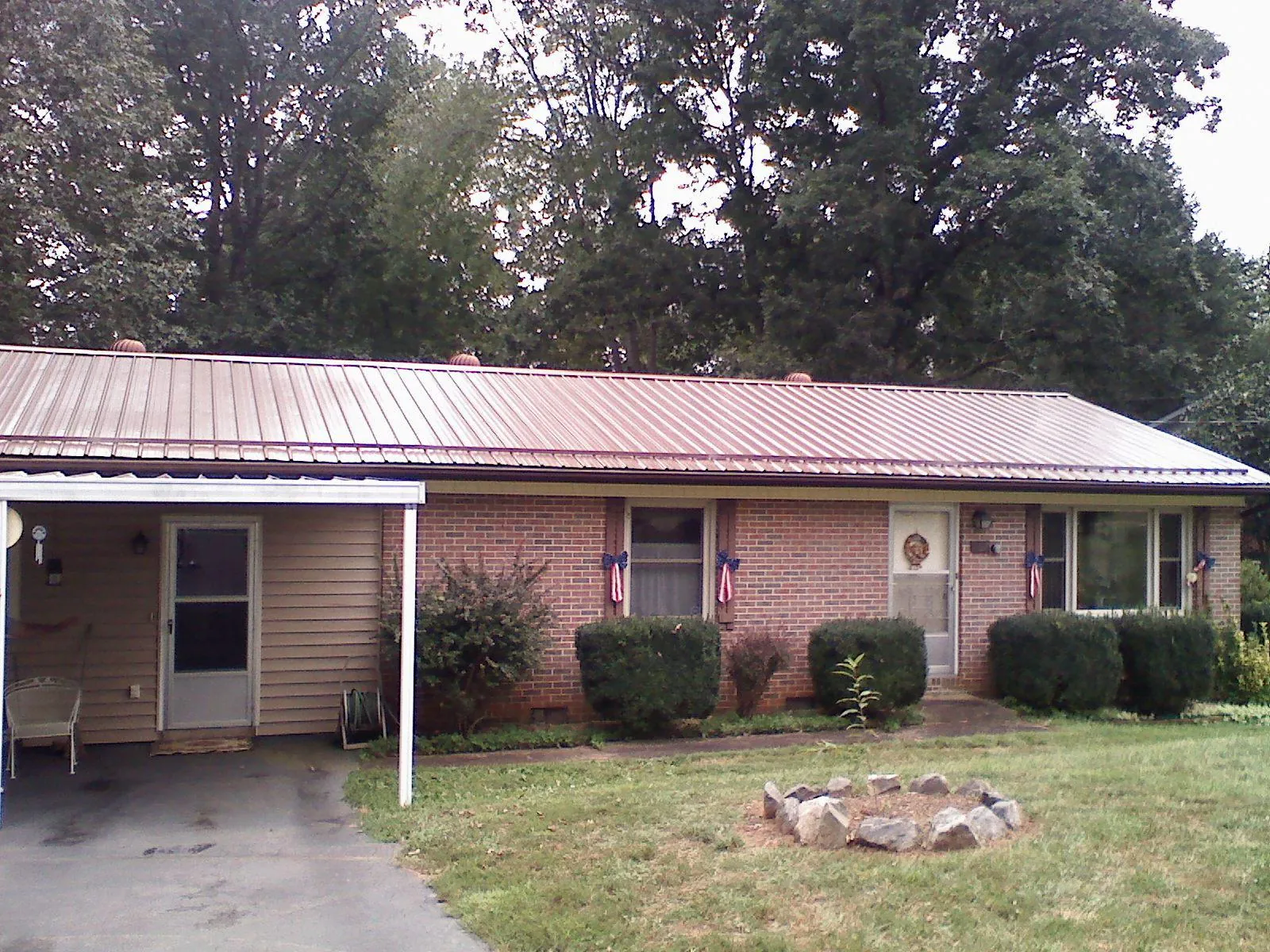 Bronze metal roof and carport on a brick ranch home — Roof Repair work by our crew in Silver Star